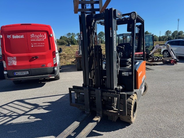 Doosan Stapler vor rotem Lieferwagen auf dem Hof