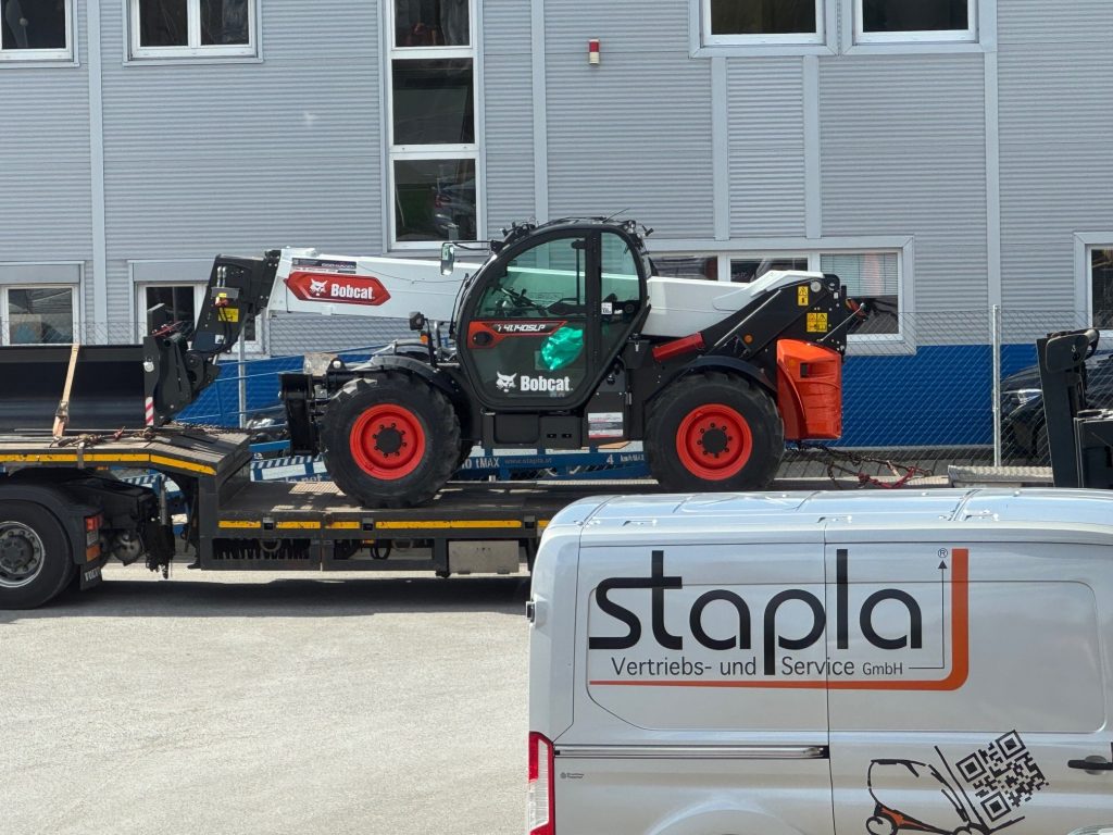 Bobcat Teleskoplader auf Tieflader neben Stapla Transporter