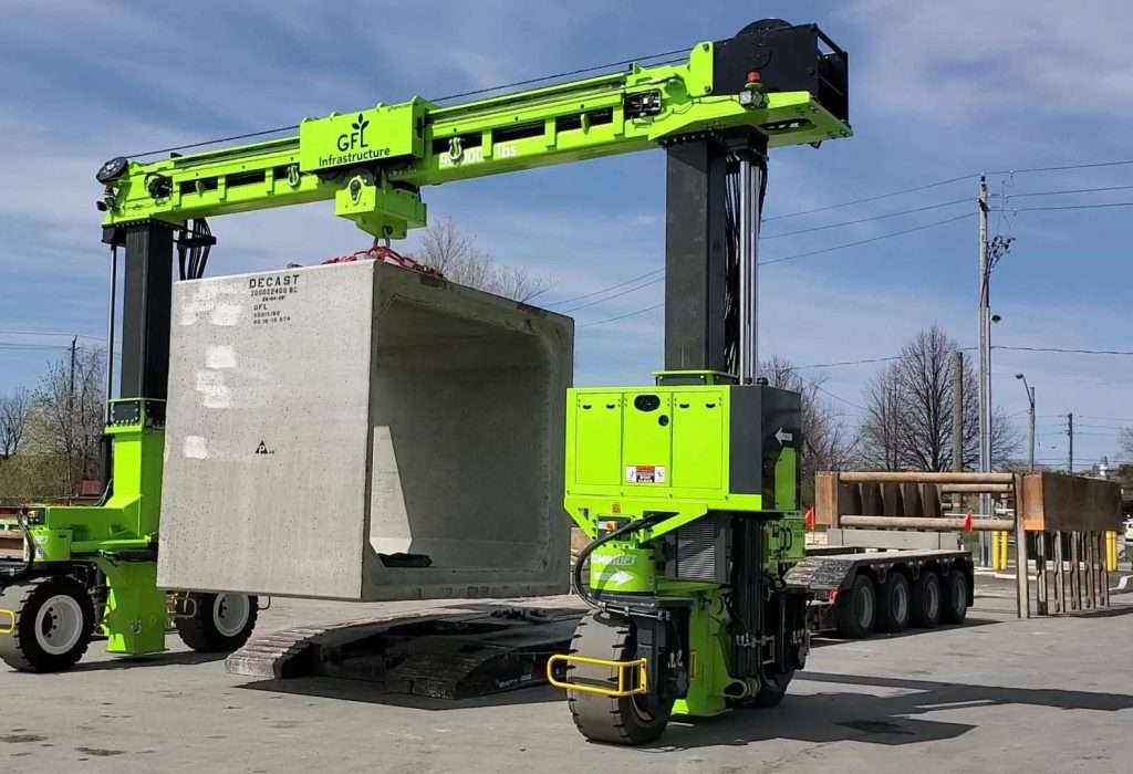 Gruener Combilift Portalstapler hebt Betonteil im Freien