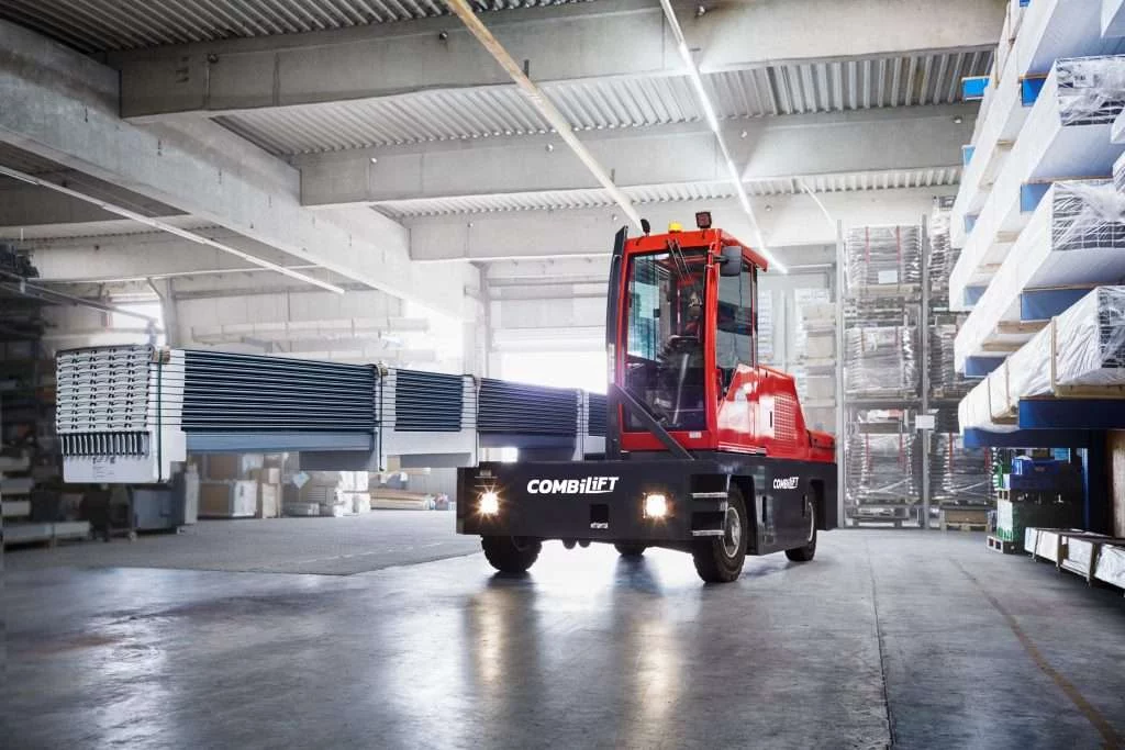 Combilift 4-Rad-Seitenstapler transportiert lange Stahlprofile in der Lagerhalle