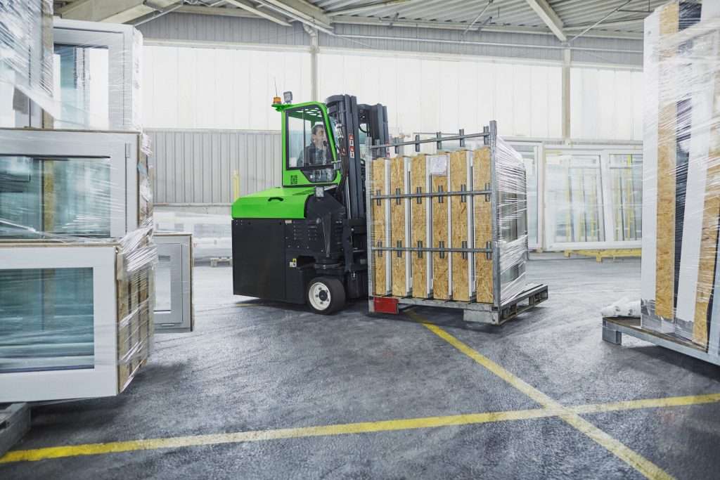 Combilift-Mehrwegestapler transportiert in einer Halle ein Gestell mit Fenstern