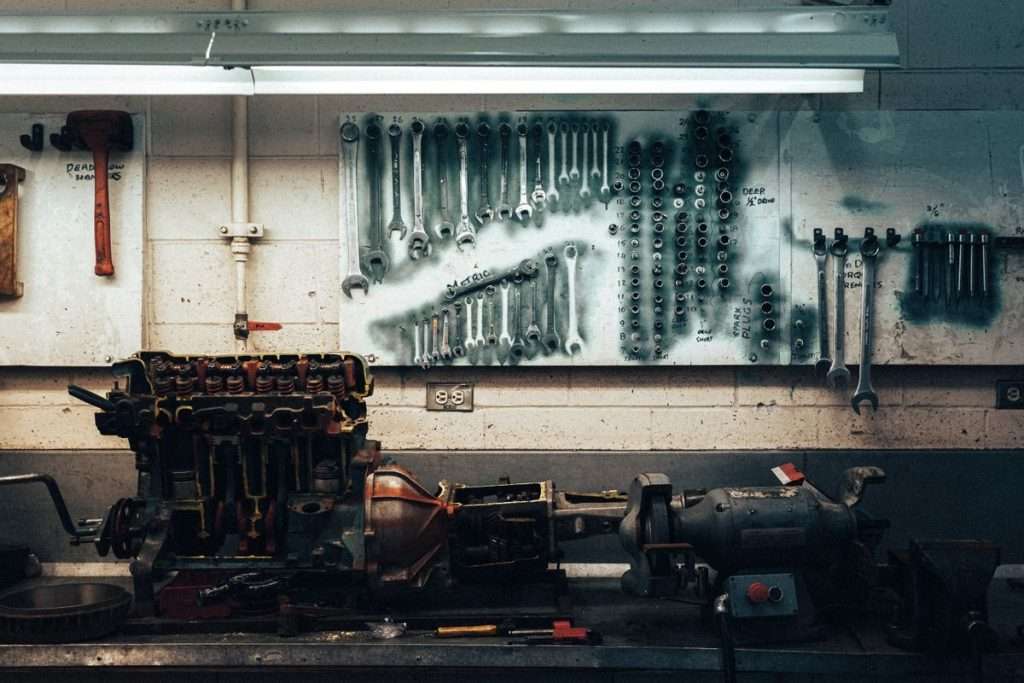 Werkstatt mit Motorblock auf Werkbank vor Werkzeugwand