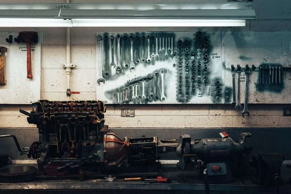 Werkstatt mit Motorblock auf Werkbank vor Werkzeugwand