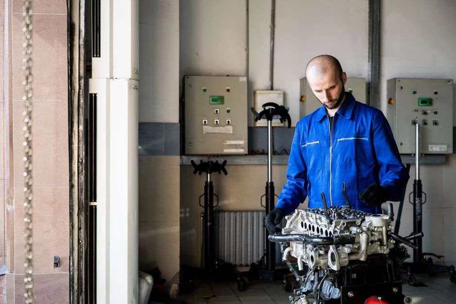 Techniker repariert Motor in der Werkstatt