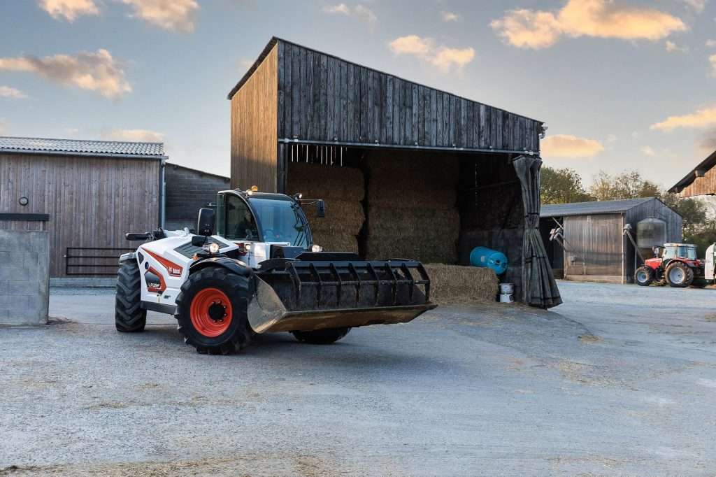Bobcat Teleskoplader mit Schaufel vor Scheune