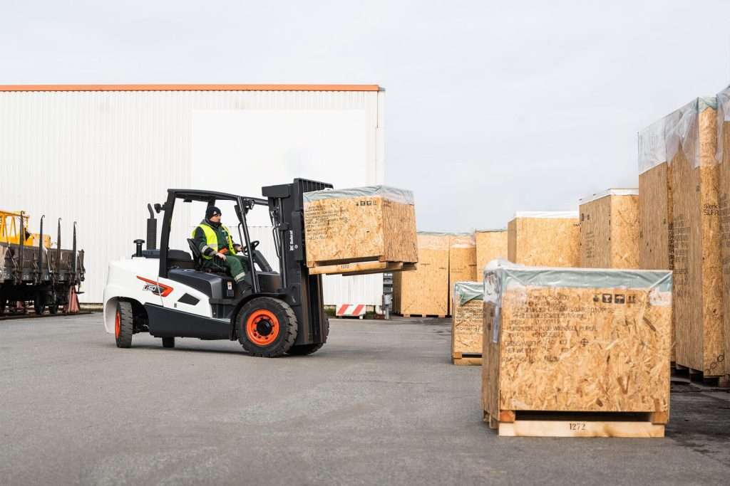 Stapler transportiert Holzkisten auf Freigelaende