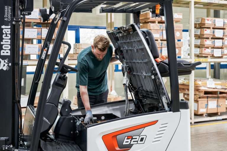 Techniker wartet Bobcat Elektrostapler bei offener Haube