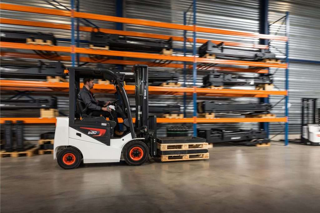 Bobcat Stapler vor langen orangen Regalen