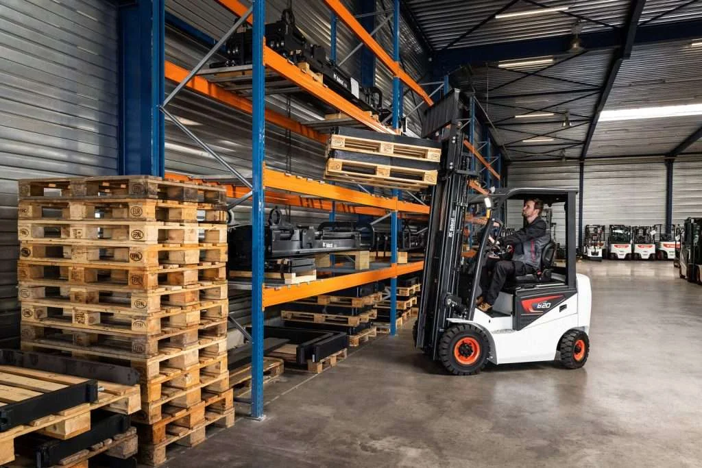 Bobcat Elektrostapler zwischen Palettenstapeln im Regallager