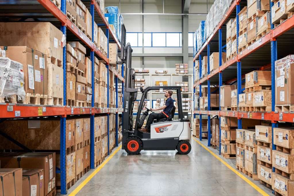 Bobcat Elektrostapler mit Fahrer im Regalgang