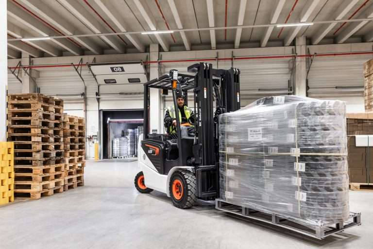 Bobcat Elektrostapler transportiert folierte Palette in Halle