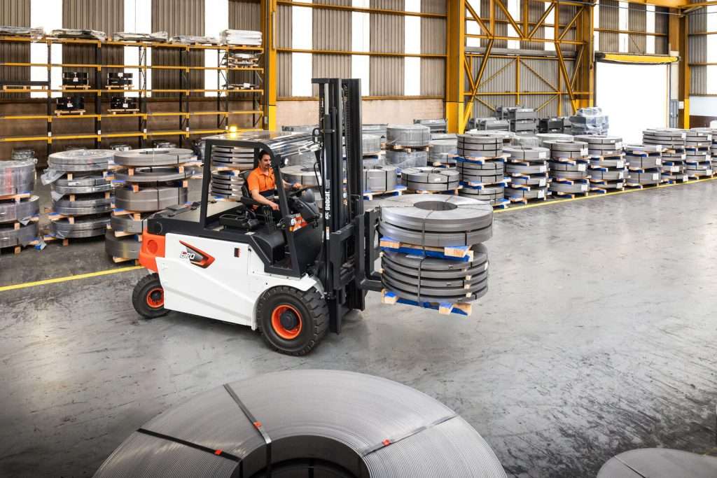 Bobcat Elektrostapler transportiert Stahlcoils in Halle