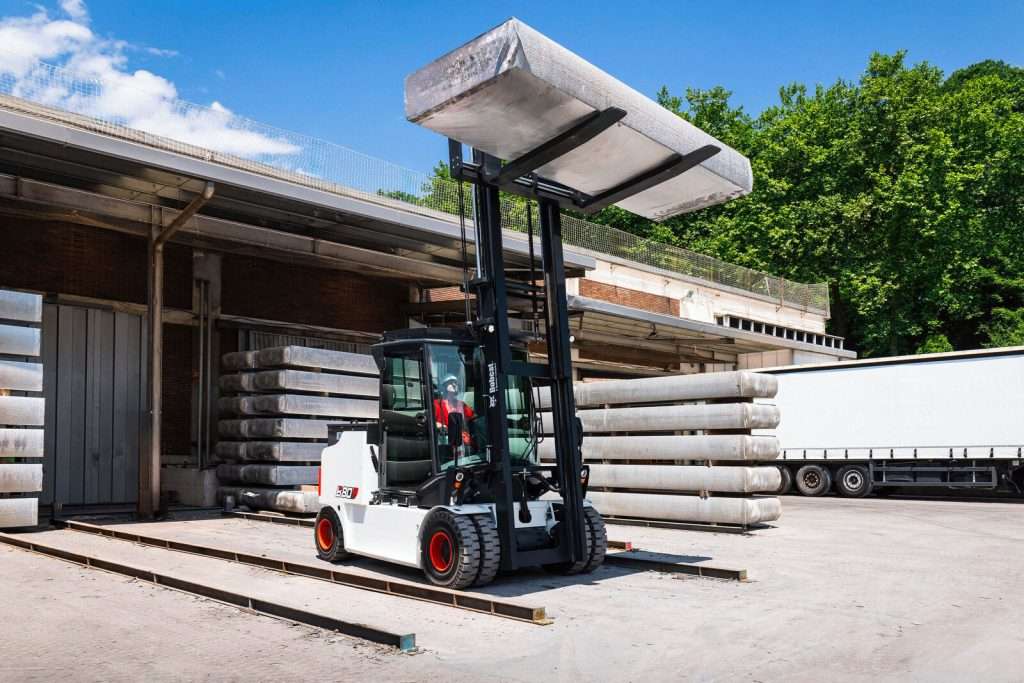 Bobcat Stapler hebt Aluminiumbuendel vor blauem Himmel