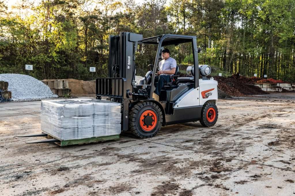 Bobcat Stapler transportiert Pflastersteine auf Lagerplatz