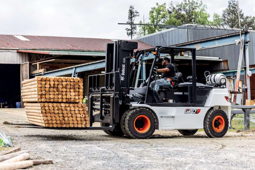 Grosser Stapler hebt Holzpaket vor Saegewerk