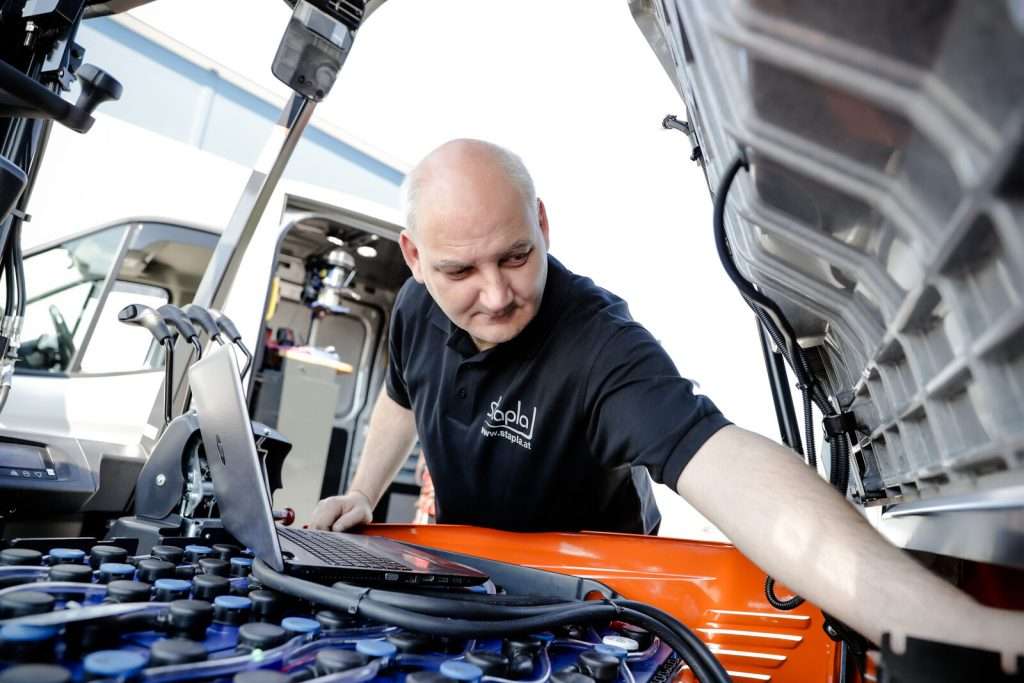 stapla Servicetechniker prüft einen Stapler mit dem Laptop