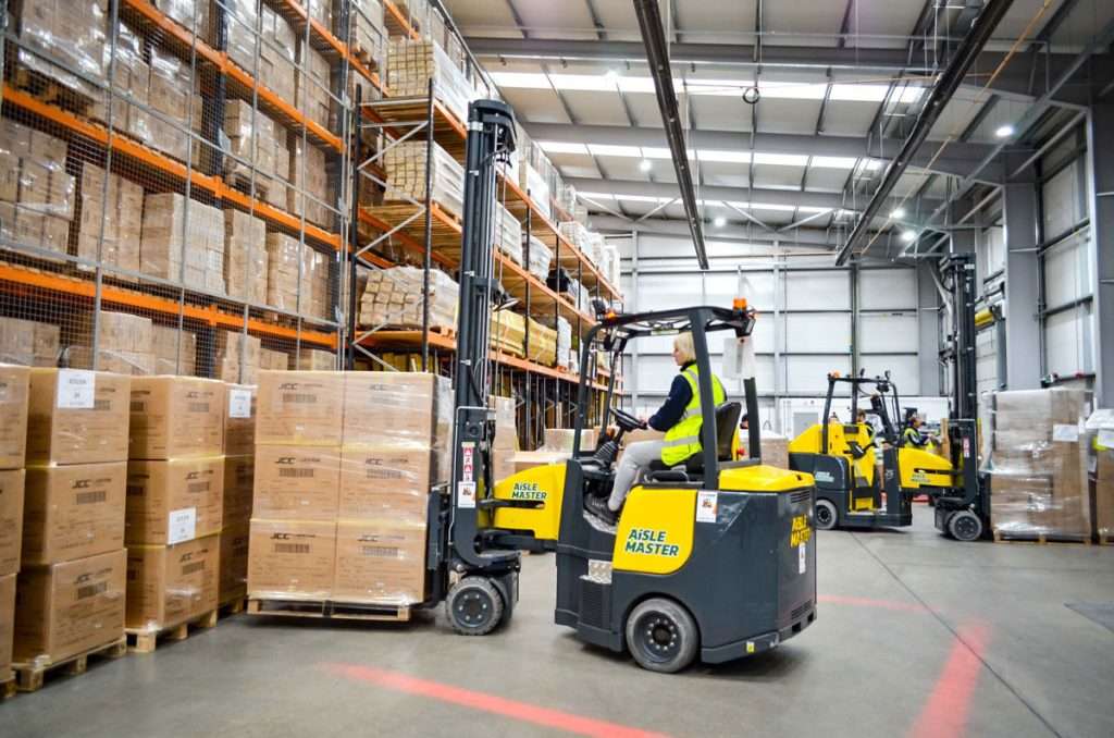 Aisle-Master Order Picker mit Fahrerin im Hochregallager